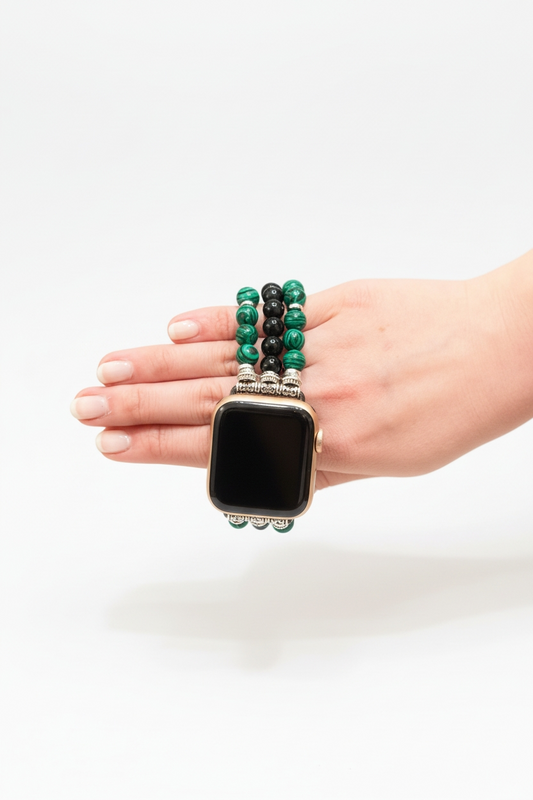 Smartwatch with a green beaded band held in a hand on a white background