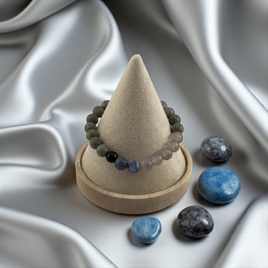 Beaded bracelet on a cone-shaped stand with stones on a textured white background