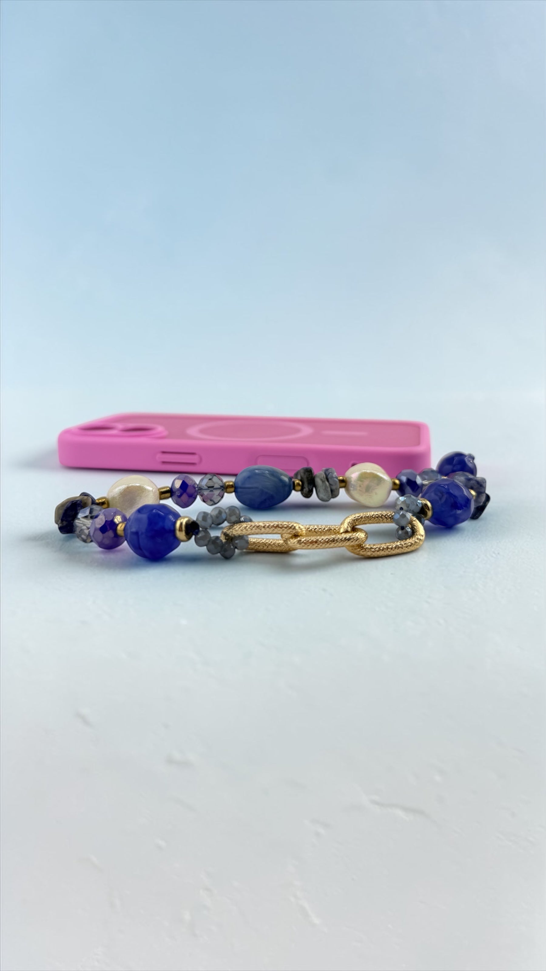 Two beaded bracelets with a pink case on a light blue background