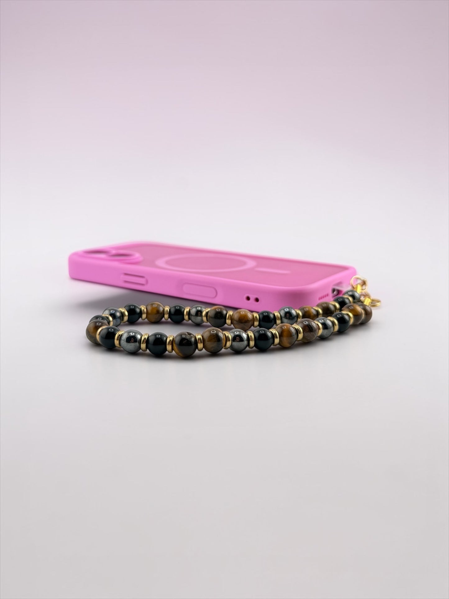 Pink phone case with a beaded chain on a light gray background