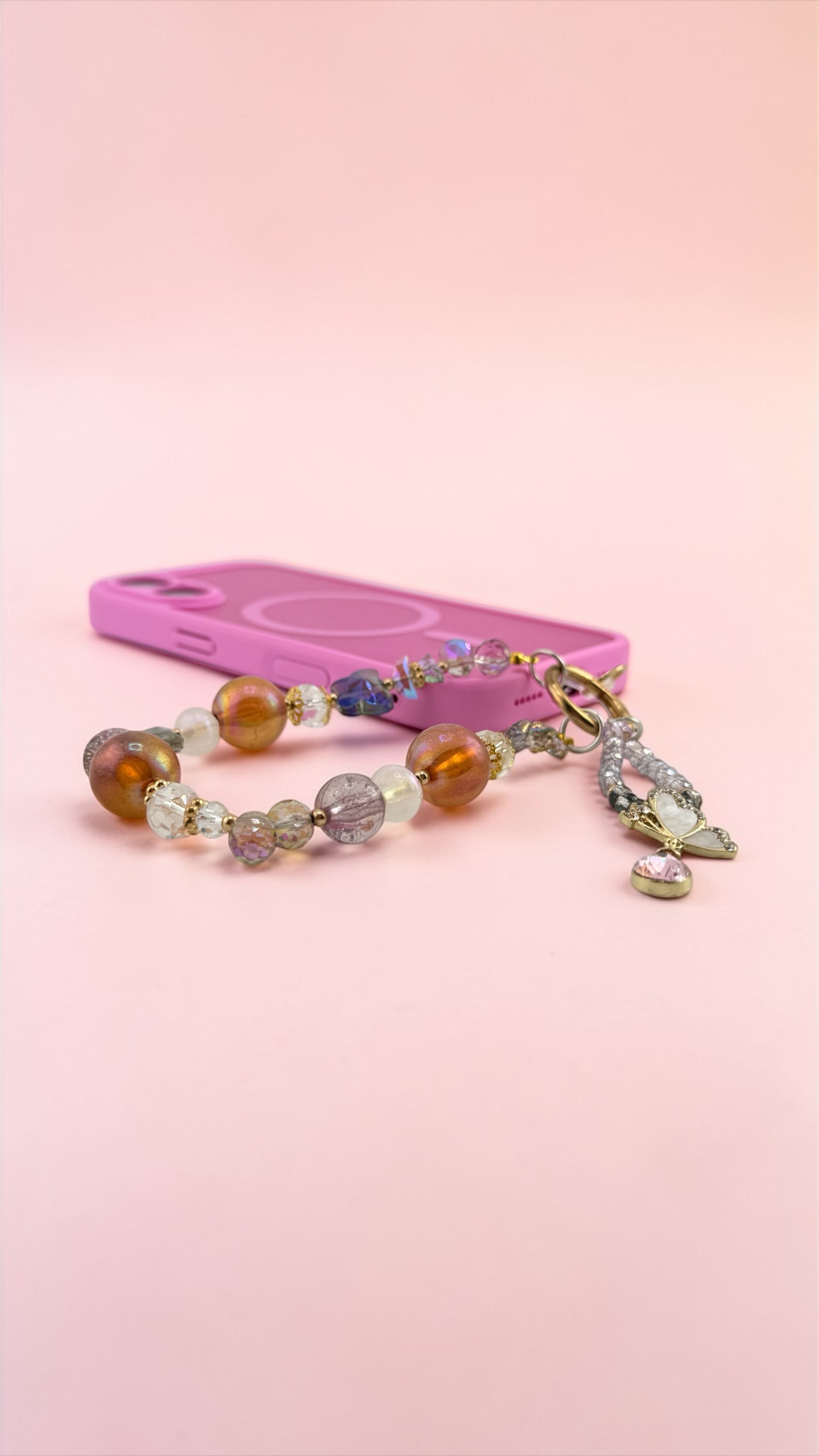 Beaded bracelet with a pink phone case on a pink background