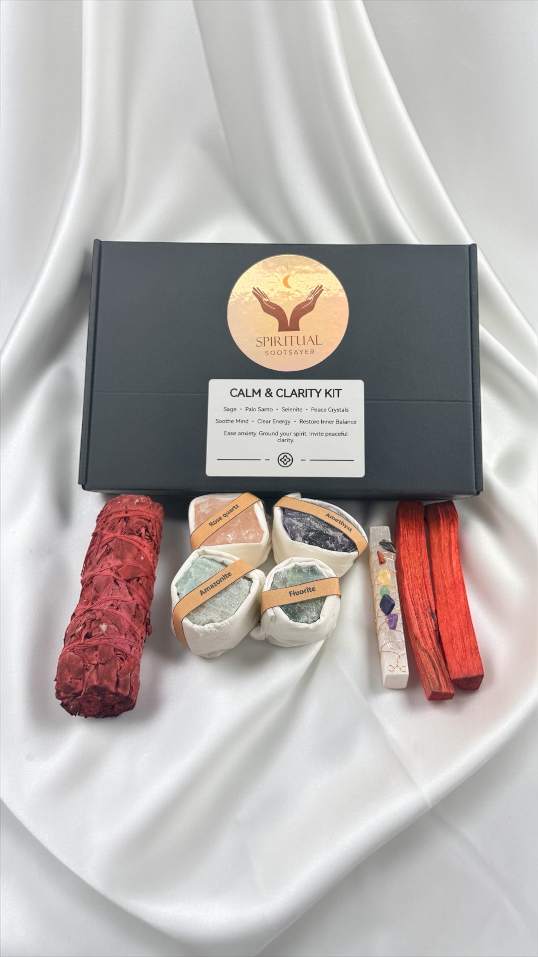Calm and Clarity Kit with incense sticks, stones, and a box on a white fabric background