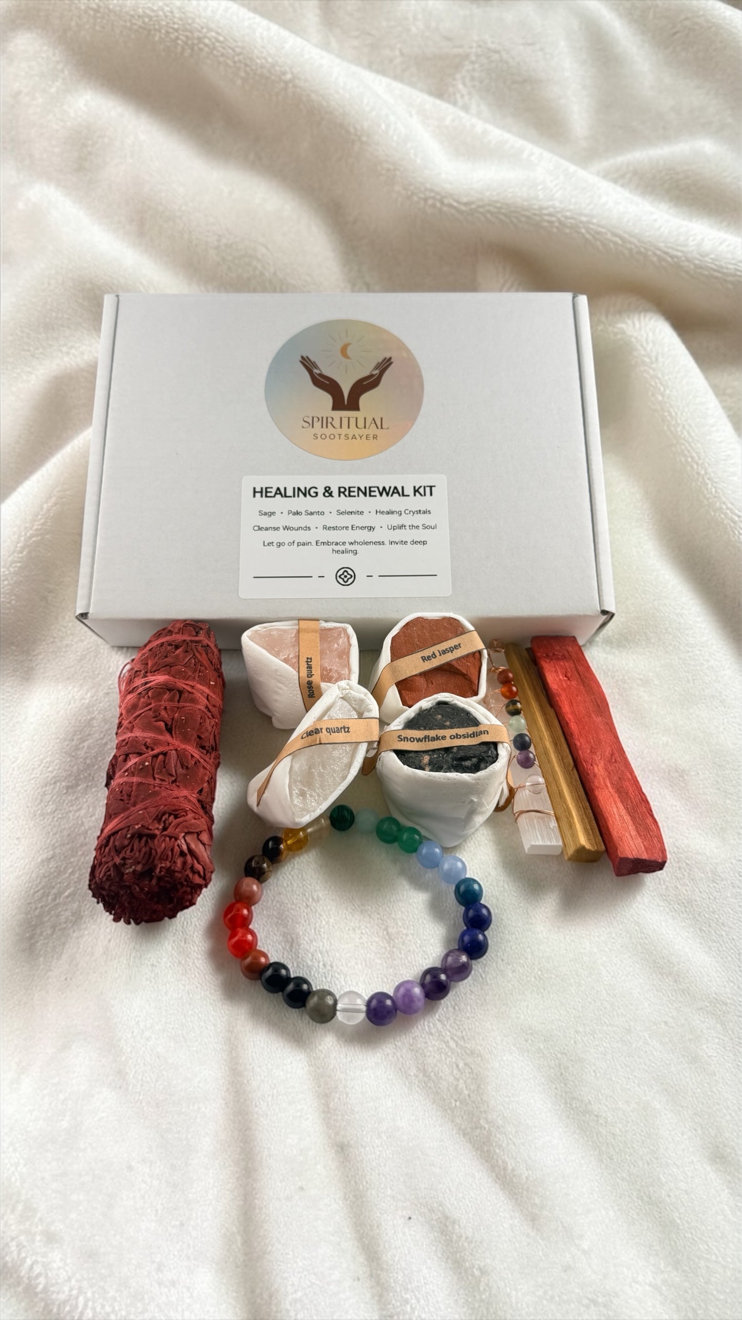 Healing and renewal kit with various items on a white blanket