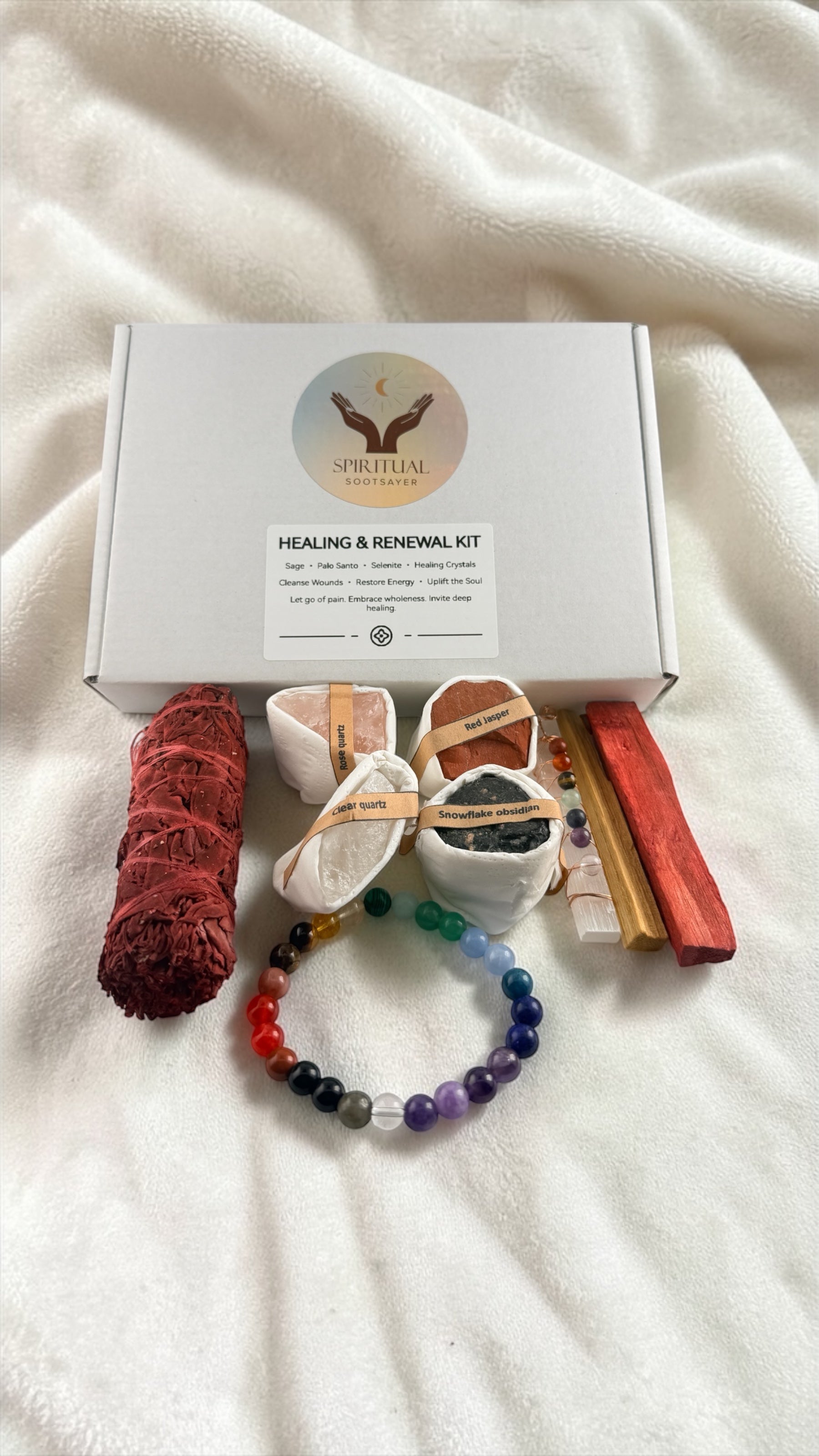 Healing and renewal kit with various items on a white blanket