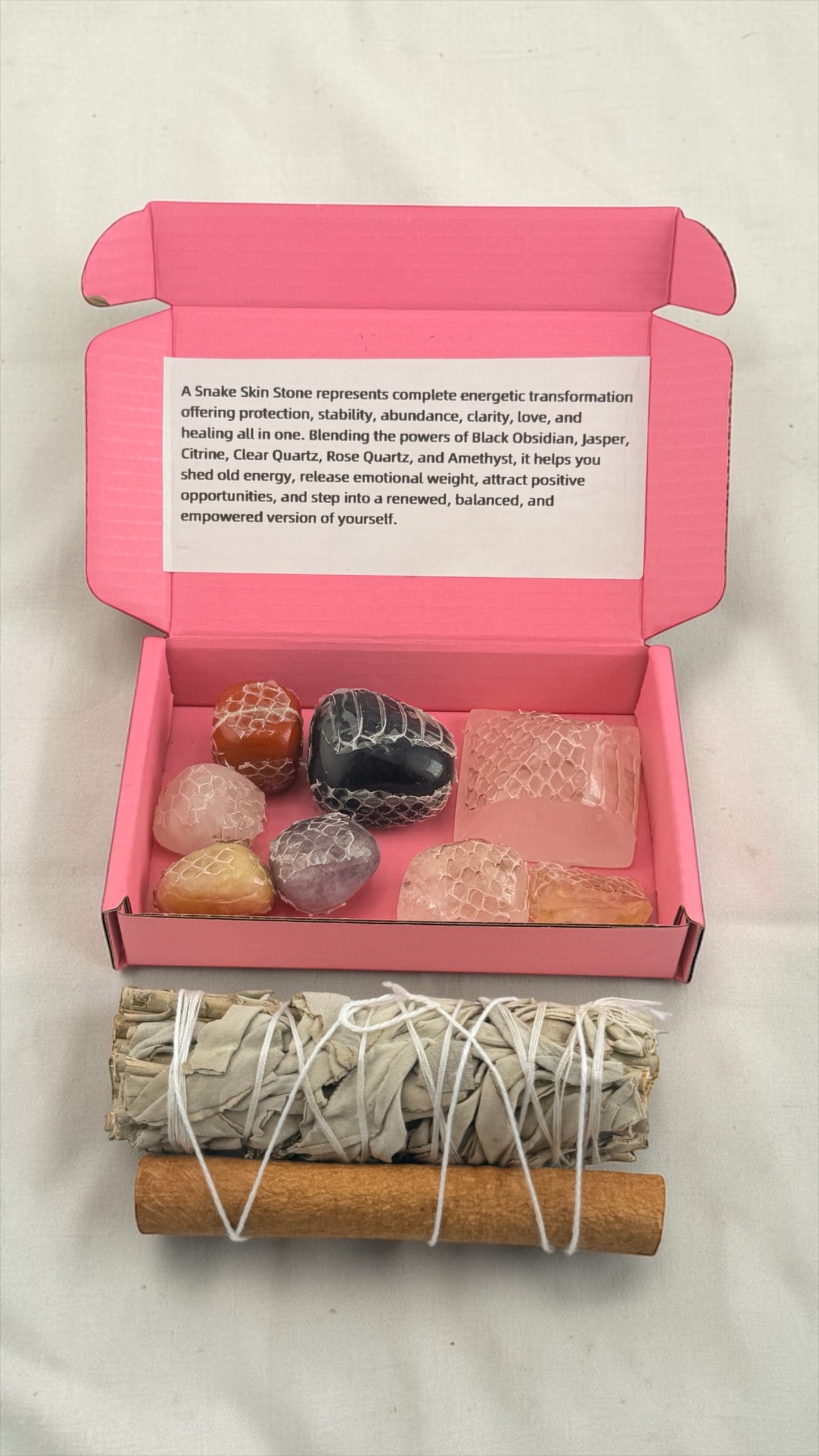 Set of stones and smudging sticks in a pink box with text on a white background