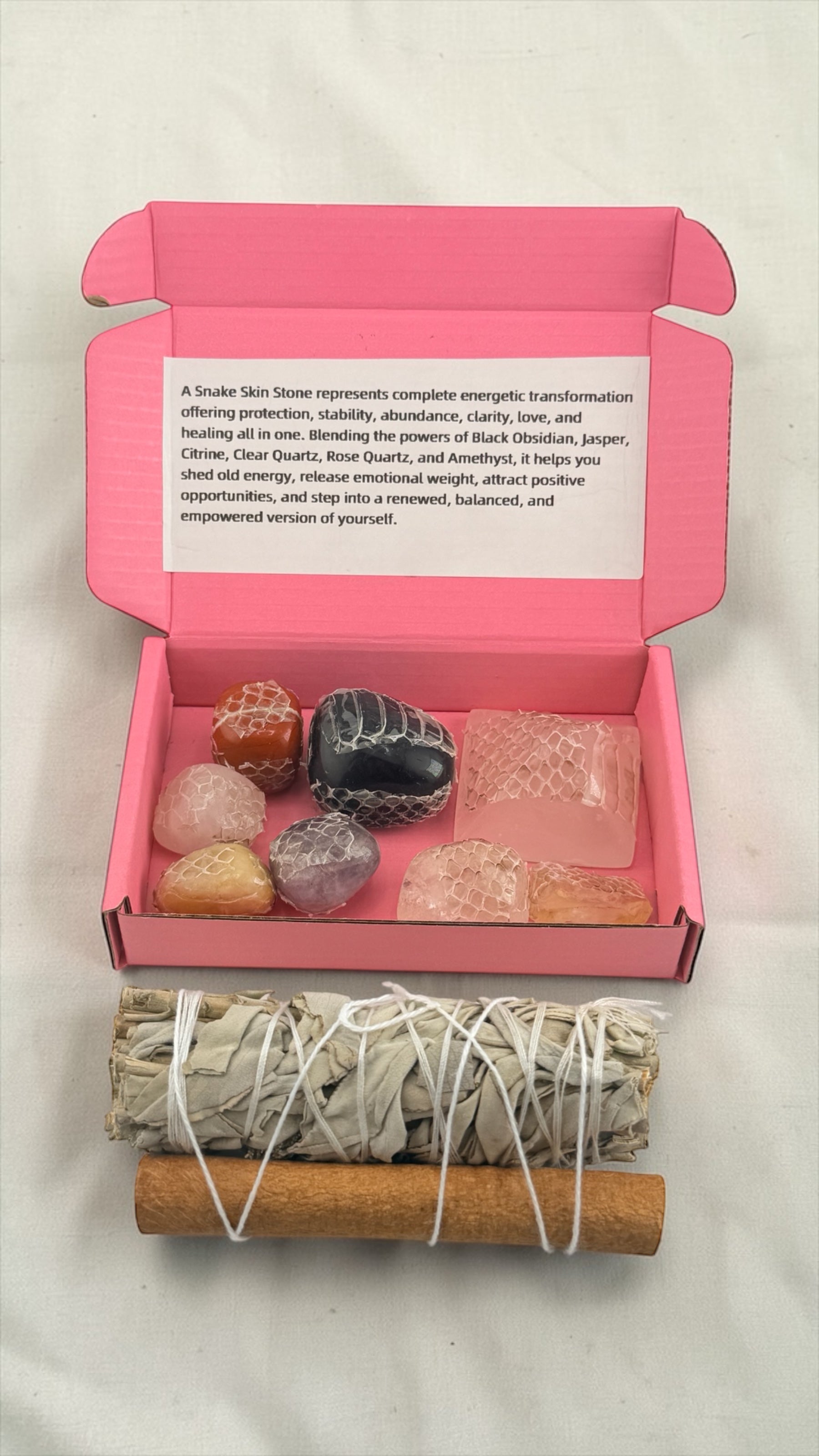 Set of stones and smudging sticks in a pink box with text on a white background