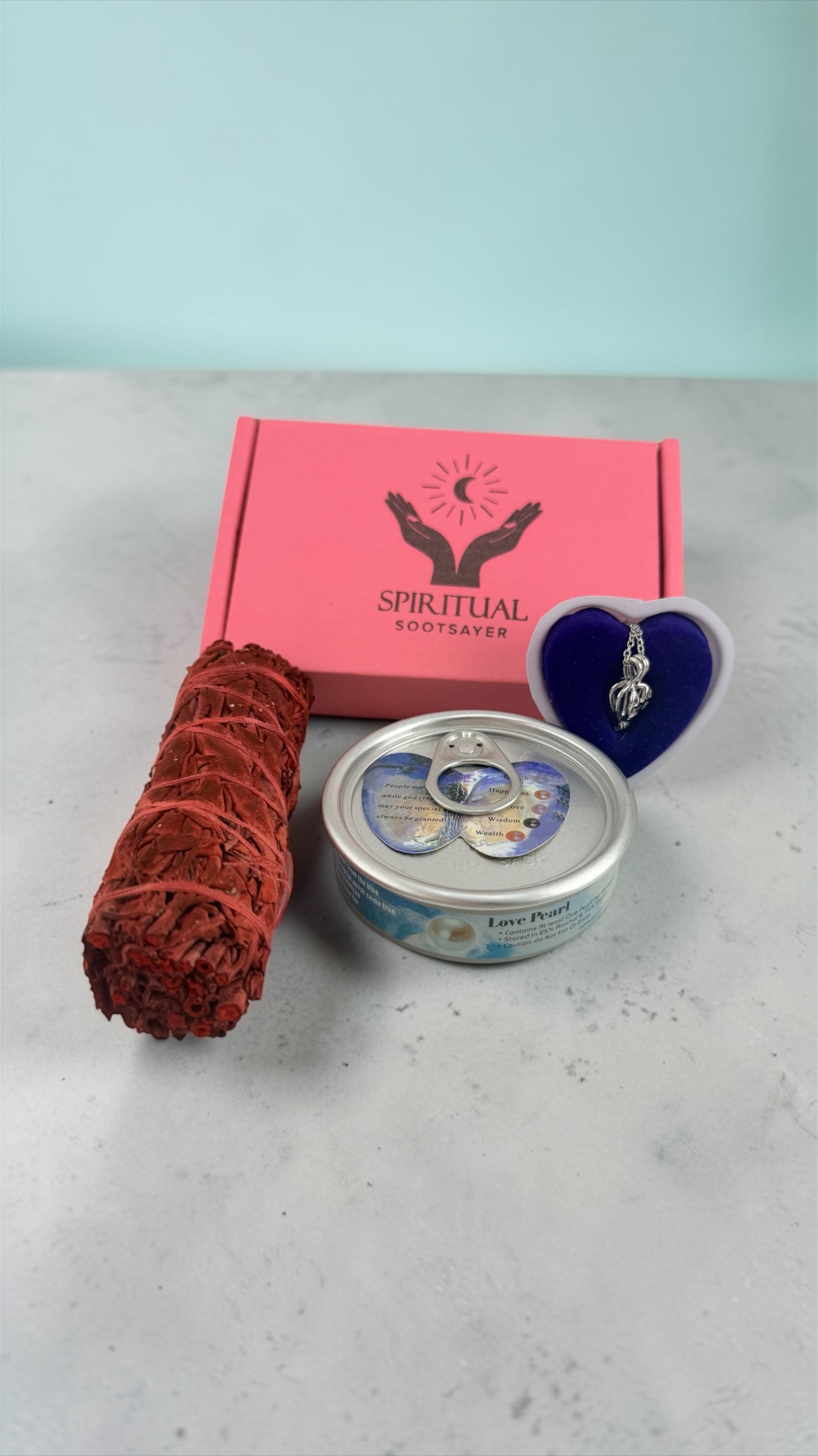 Candle, incense stick, and small container on a light surface with a pink box labeled 'Spiritual'.