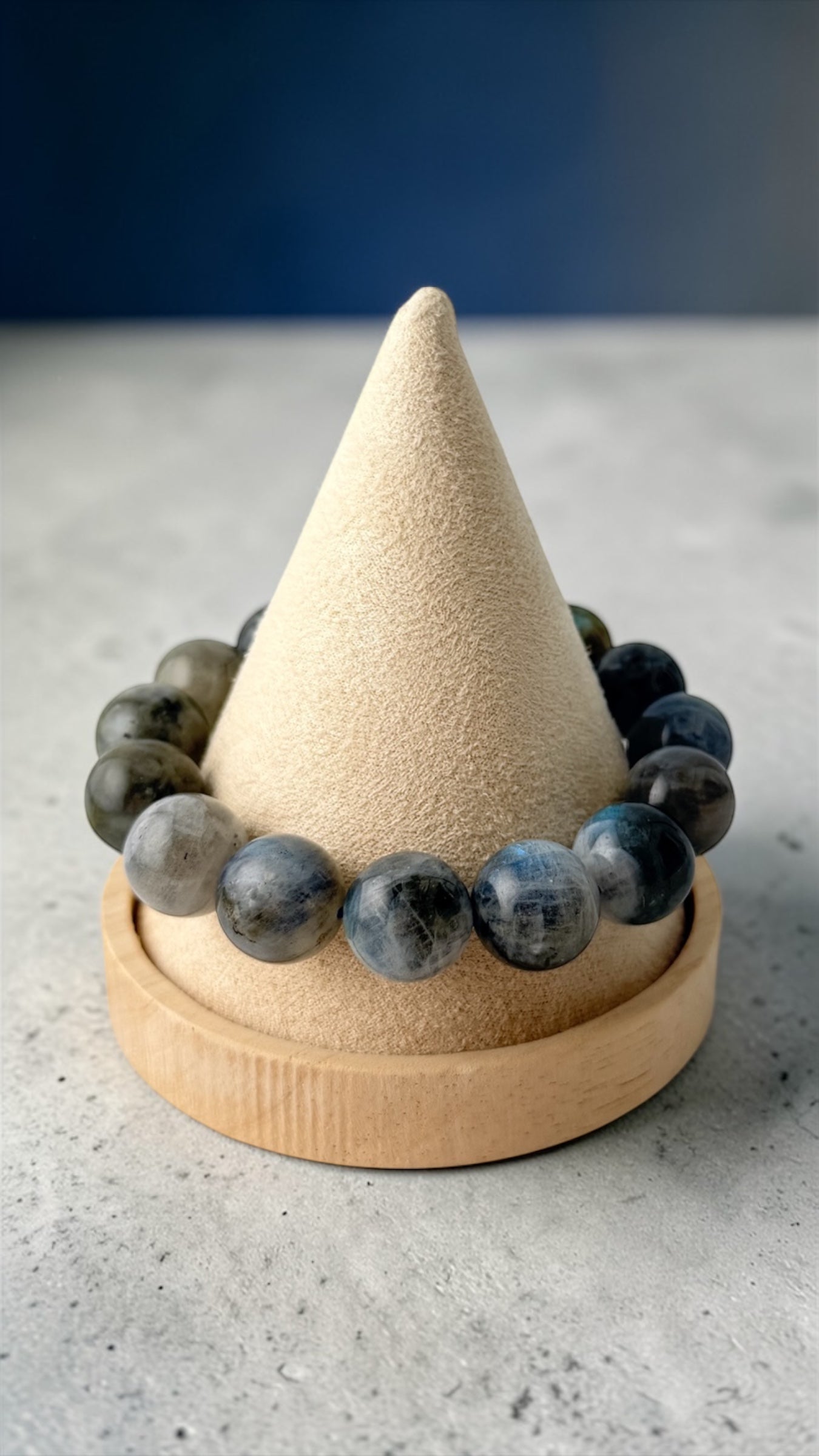 Beaded bracelet on a wooden cone with a blue background