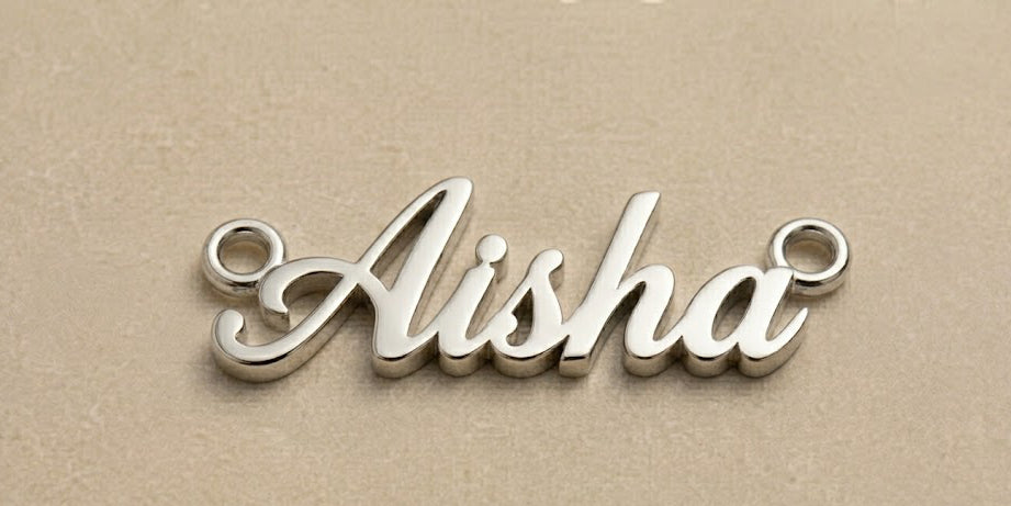 Silver name pendant with 'Aisha' on a beige background