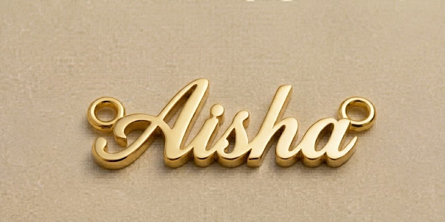 Gold nameplate with 'Aisha' on a beige background