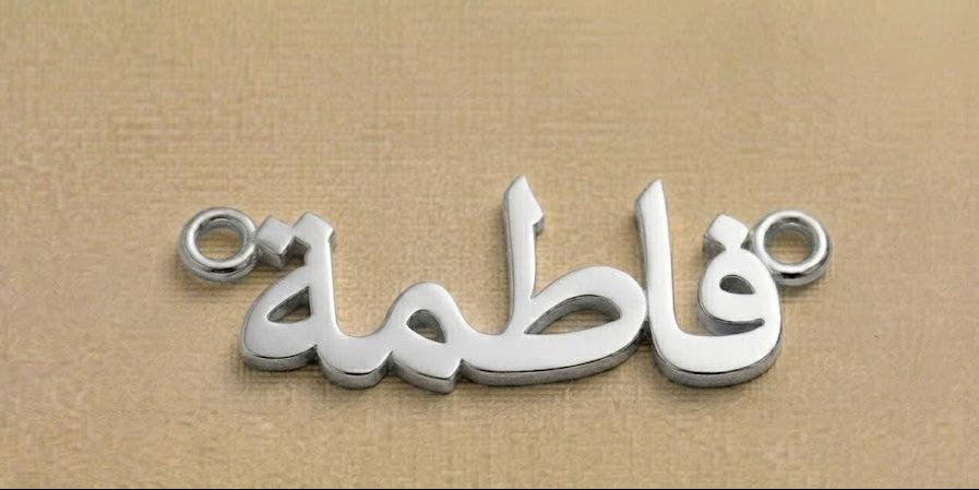 Silver nameplate with Arabic text on a beige background