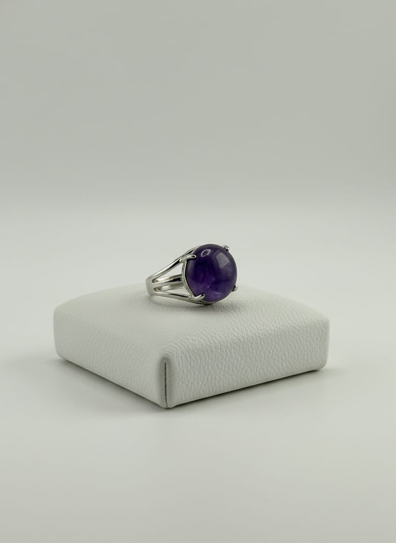 Silver Amethyst men’s ring on hand with soft indoor lighting