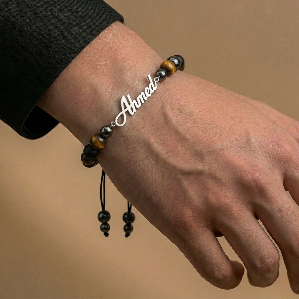 Bracelet with 'Ahmed' engraving on a wrist against a beige background