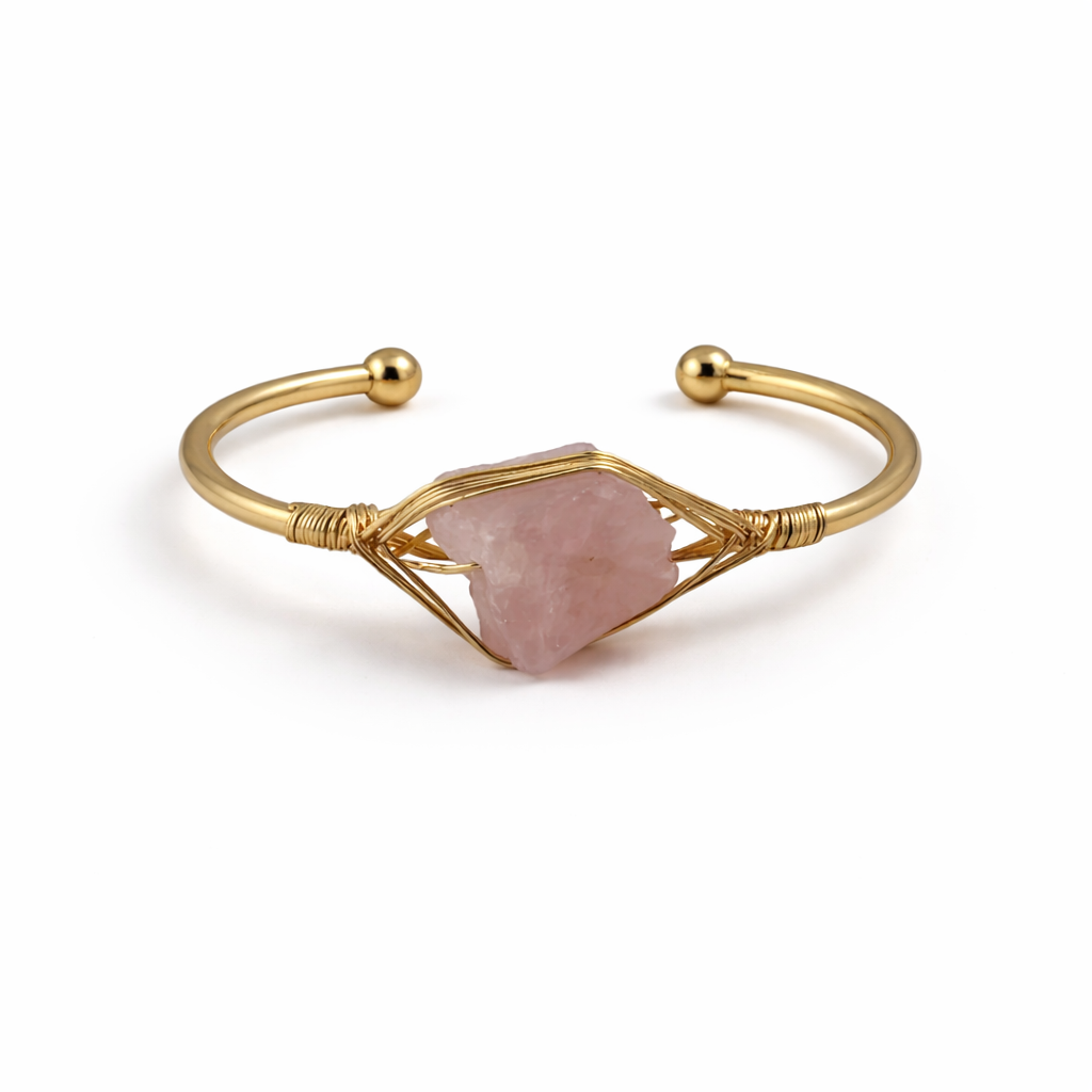 Gold bracelet with a pink stone on a white background