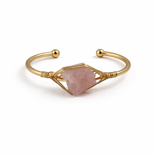 Gold bracelet with a pink stone on a white background