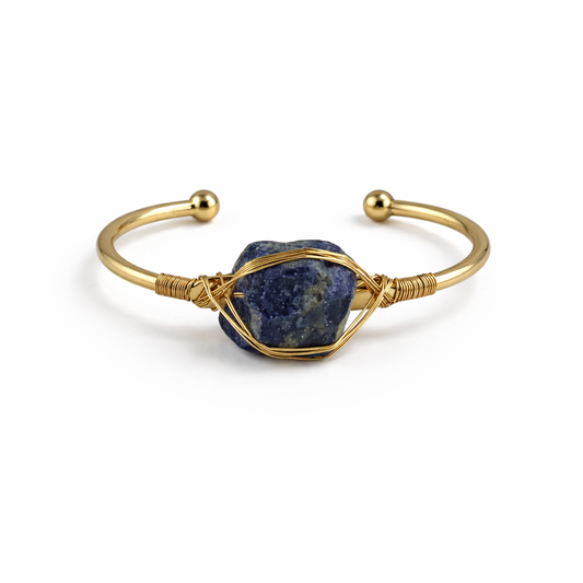 Gold bracelet with a blue stone on a white background