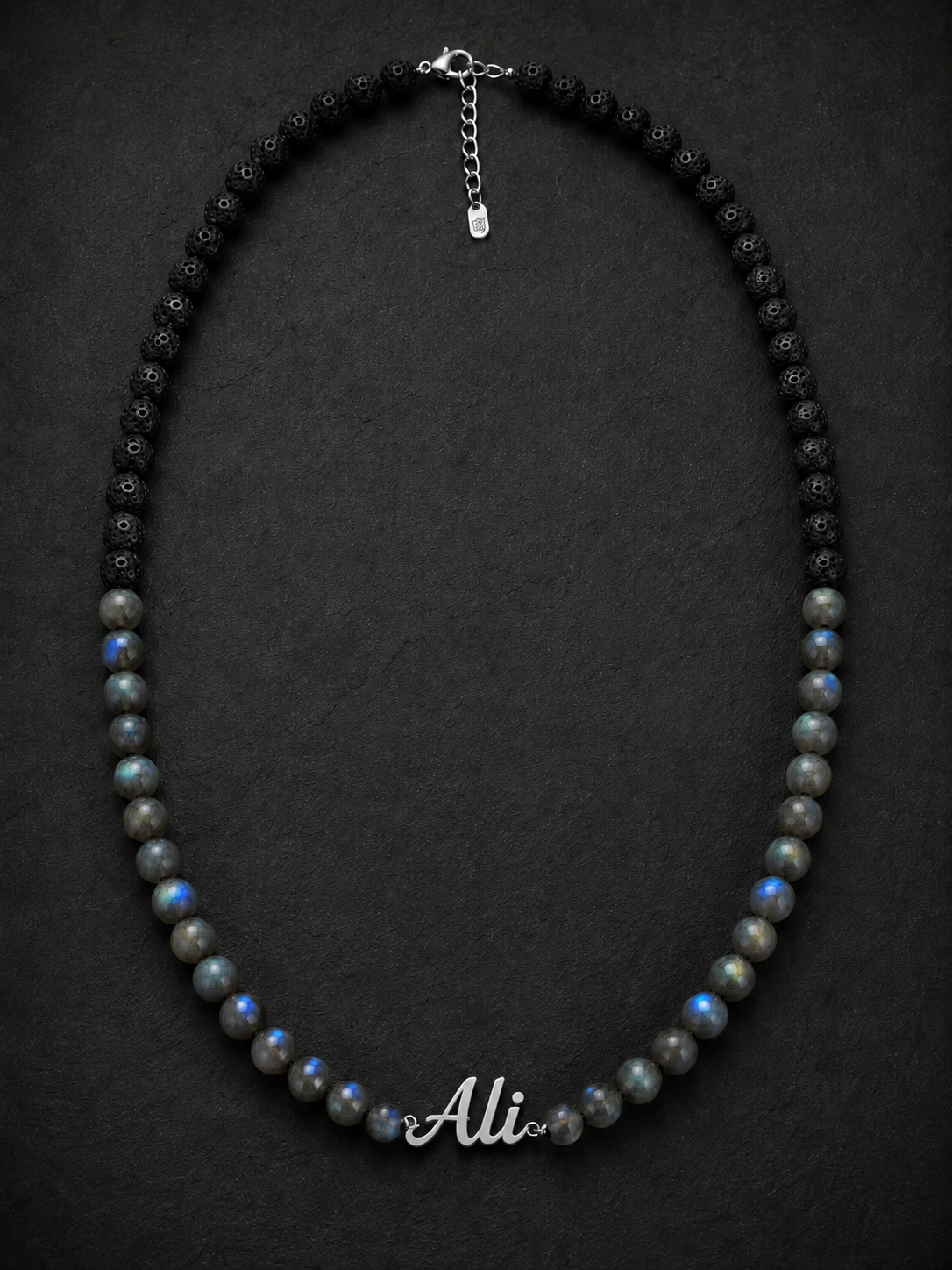 Necklace with black and gray beads and a nameplate on a dark background