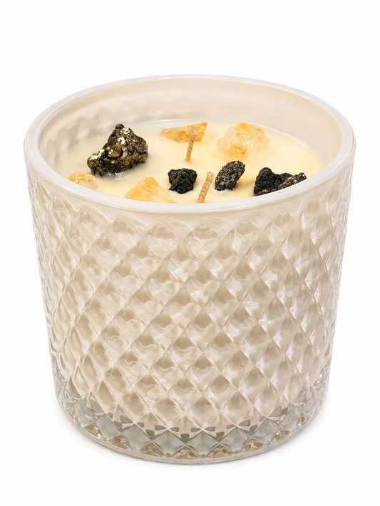 Candle in a textured glass container with decorative elements on a white background