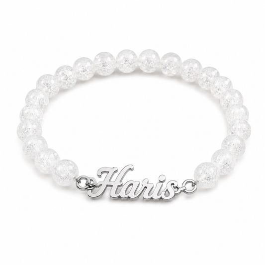 Pearl bracelet with a silver 'Harris' charm on a white background
