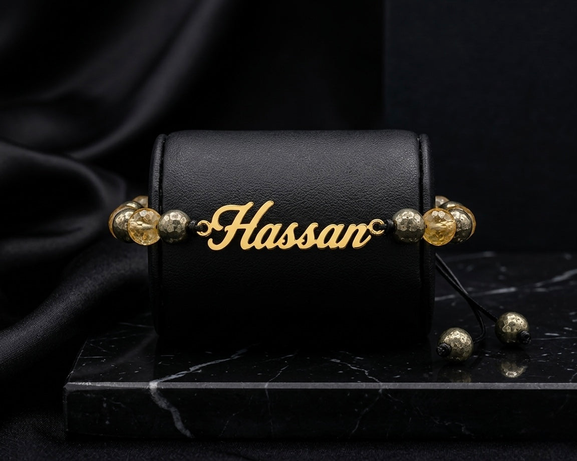 Black leather case with gold beads and 'Hassan' engraving on a dark background
